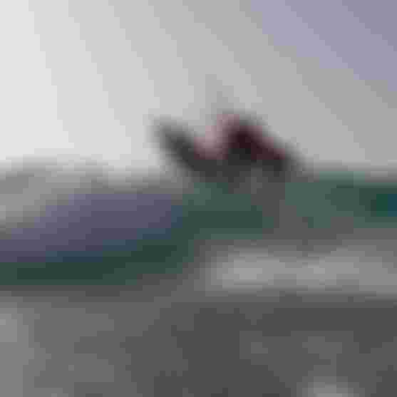 Matchu skillfully kiteboarding on a wave with the Duotone wave kite and a directional board.