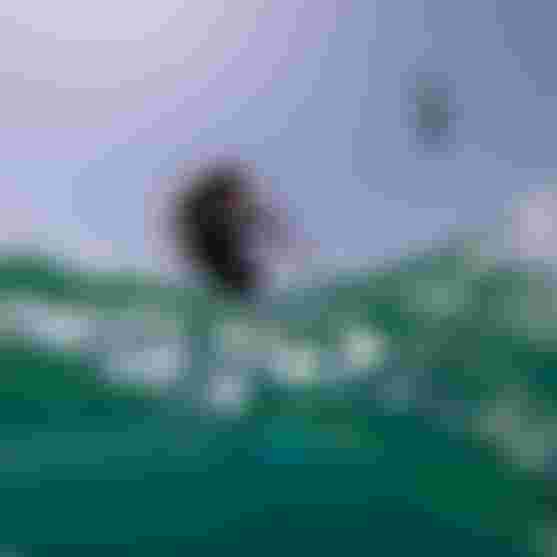 Julia Castro kiteboarding on the ocean, partially submerged in water, with a clear blue sky in the background.