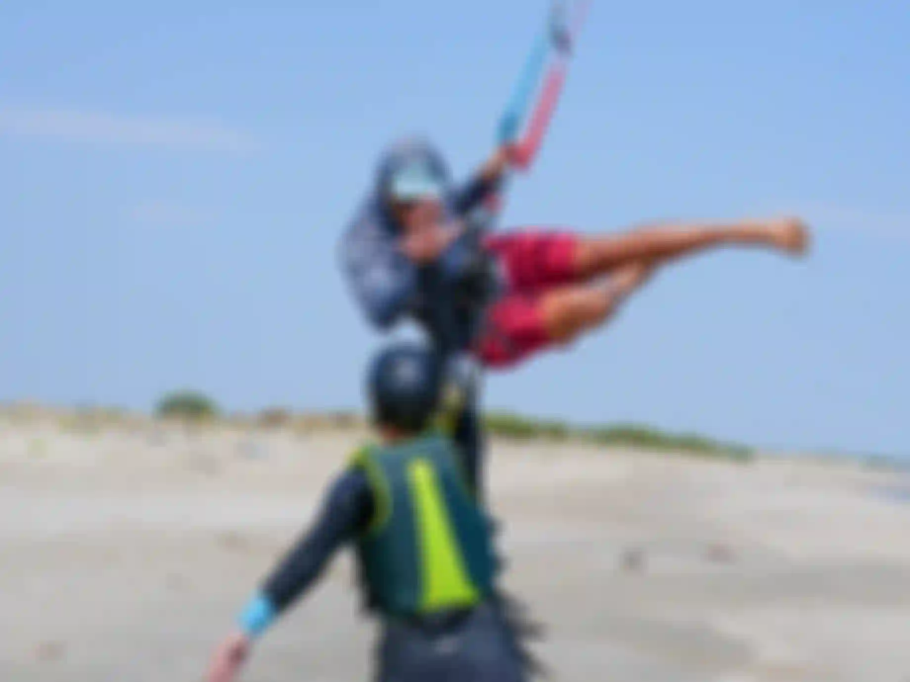 Kite instructor on the beach with his student