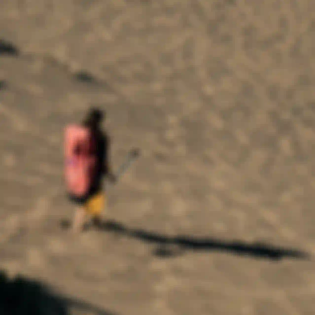 Duotone SUP Rider walkind downhill with backpack and paddle