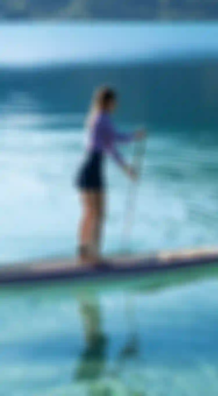 Female SUP rider paddling with the Raven Bamboo on an Austrian lake