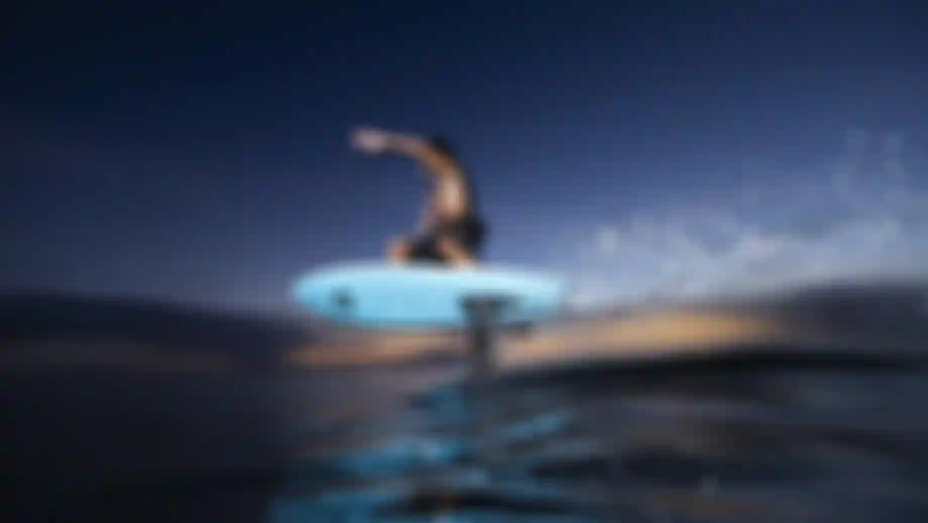 Matahi Drollet carving with the Midfish on flat water at night