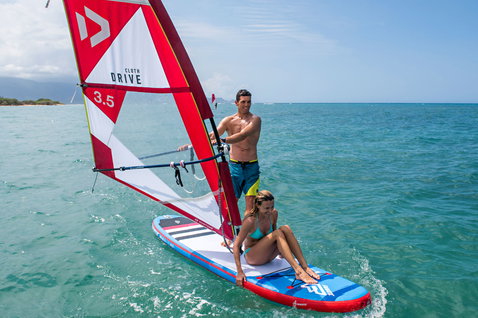 Duotone Drive Cloth freeride windsurf sail 3.5 m² during windsurfing in the tropical ocean with sandy beach in the background