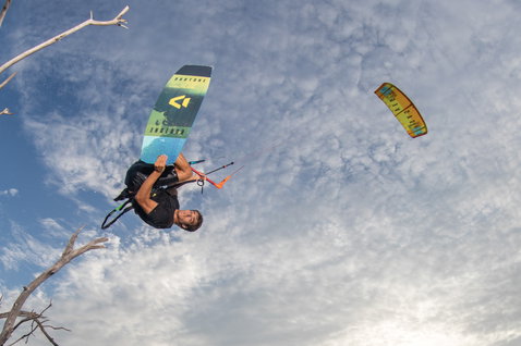 Duotone Vegas LEI kite durante kitesurf en un paisaje árido con árboles secos