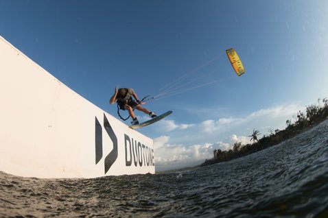 Duotone Vegas LEI kite durante wakestyle en una laguna costera tropical con palmeras