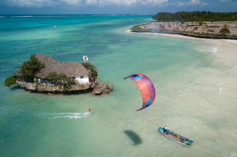 Duotone Dice LEI kite during kitesurfing over a tropical ocean lagoon with island