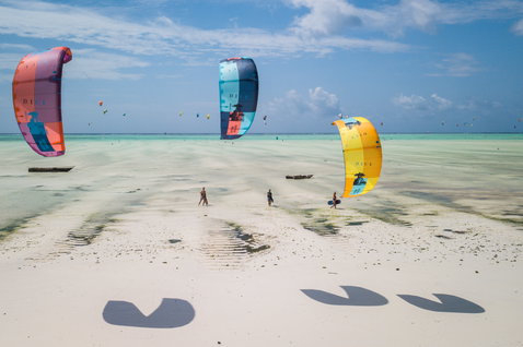 Duotone Dice LEI kite during kitesurfing on a tropical beach with shallow turquoise water and white sand