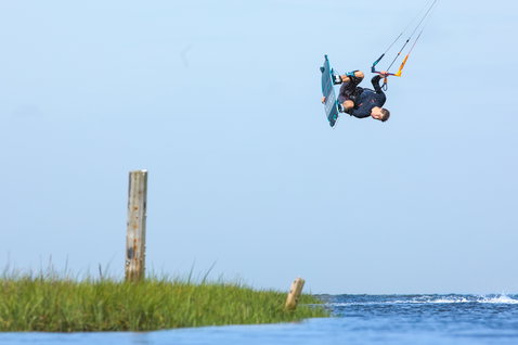 Duotone Team Series TS Hadlow tabla de kitesurf twin-tip durante el kitesurf en laguna costera de aguas planas
