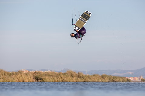 Tabla de kitesurf twin-tip Duotone Team Series durante el kitesurf en una laguna costera con cañaverales