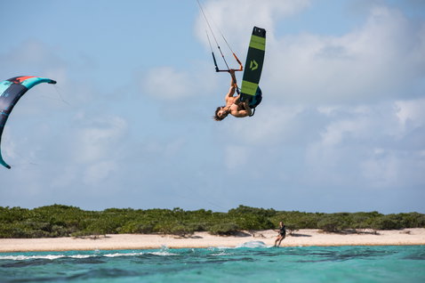 Duotone Select Textreme twin-tip kiteboard durante il kitesurf in una laguna tropicale