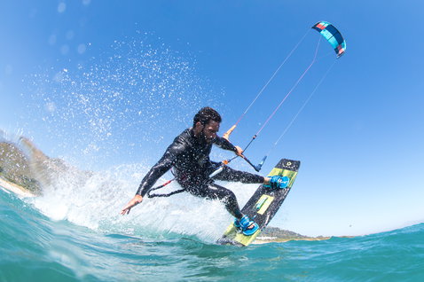 Duotone Select Textreme twin-tip kiteboard durante il kitesurf sulla spiaggia