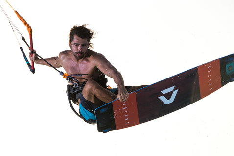 Duotone Select kiteboard twin-tip durante il kitesurf su sfondo bianco da studio