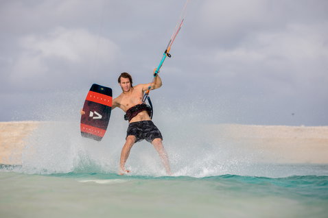 Duotone Select twin-tip kiteboard durante il kitesurf in una laguna oceanica poco profonda con spiaggia sabbiosa