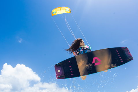 Duotone Soleil Twin-Tip Kiteboard beim Kitesurfen über dem Ozean in der Luft