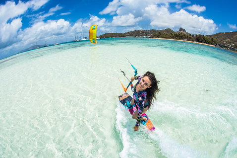 Duotone Soleil Twin-Tip Kiteboard beim Kitesurfen in einer tropischen Lagune mit Palmen und Bergküste