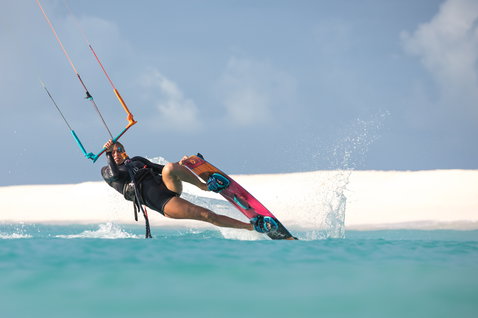 Duotone Trust Bar Quad Control Kitesurf-Steuerbar beim Kitesurfen an einem tropischen Strand mit weißen Sanddünen