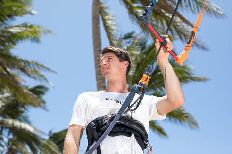 Duotone Quick Release Wakestyle Kit barre de contrôle pendant le kitesurf sur une plage tropicale avec palmiers