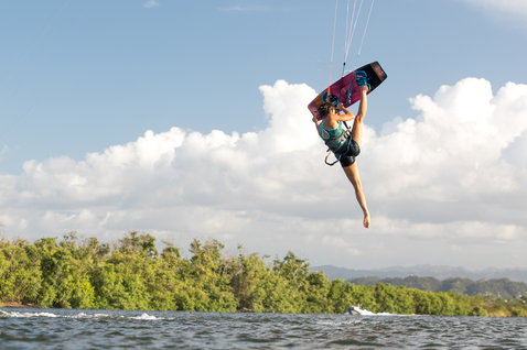 Duotone Soleil Twin-Tip Kiteboard beim Kitesurfen an einer Küstenlagune mit tropischer Vegetation