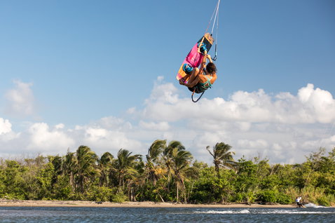 Duotone Soleil Twin-Tip Kiteboard beim Kitesurfen in einer tropischen Lagune mit Palmen