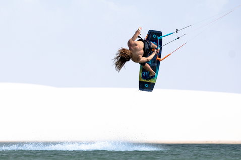 Duotone Trust Bar Quad Control Control Bar beim Kitesurfen in einer Küstenlagune mit weißen Sanddünen