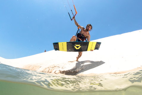 Duotone Select Textreme 2019 Select kiteboard twin-tip durante il kitesurf su una spiaggia tropicale con acque basse