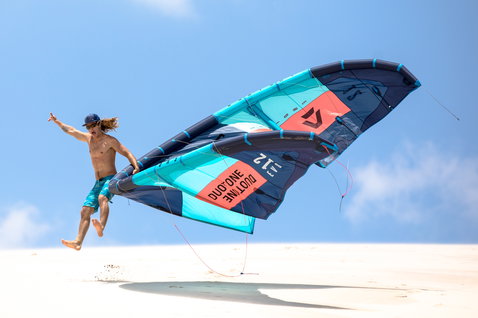 Duotone Evo LEI kite 12m during kitesurfing on a sandy beach with dunes