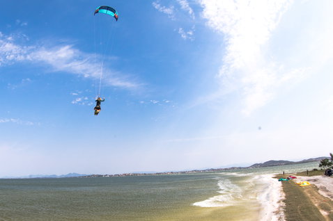Duotone Evo LEI kite during kitesurfing at a coastal beach lagoon with mountains in the background