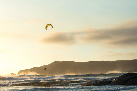 Duotone Neo LEI kite during wave riding at the rocky ocean coastline