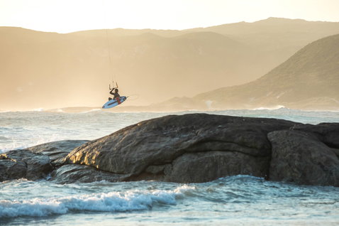 Duotone Pro Wam kite surfboard lors du kitesurf sur une côte rocheuse avec montagne en Australie