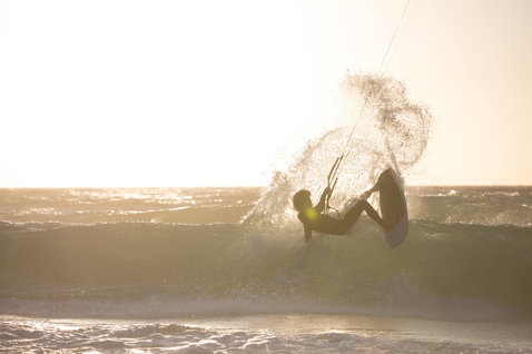 Duotone Whip CSC wave kiteboard lors du surf de vagues sur une plage océanique