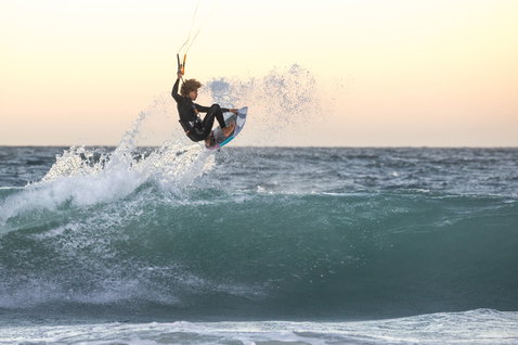 Duotone Whip CSC kiteboard directionnel lors du surf de vagues sur la plage