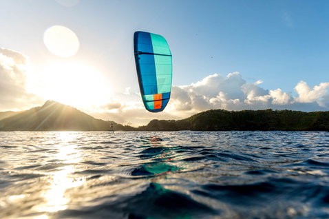 Duotone Juice LEI Kite beim Kitesurfen in einer tropischen Ozeanlagune vor bewaldeten Hügeln