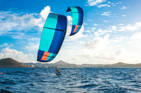 Duotone Juice LEI Kite beim Foilen in einer tropischen Meeresbucht mit Bergküste