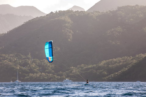 Duotone Juice LEI Kite beim Kitesurfen in einer tropischen Bucht mit grünem Bergpanorama