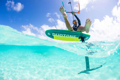 Duotone Free kiteboard de foil lors d'une session de foil en eau turquoise tropicale peu profonde
