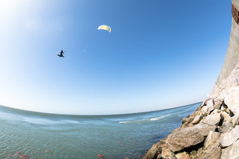Duotone Rebel LEI kite durante il kitesurf su una costa rocciosa con l'oceano