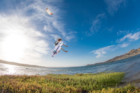 Duotone Dice LEI Kite beim Kitesurfen an einer Küste mit Lagune und Bergen