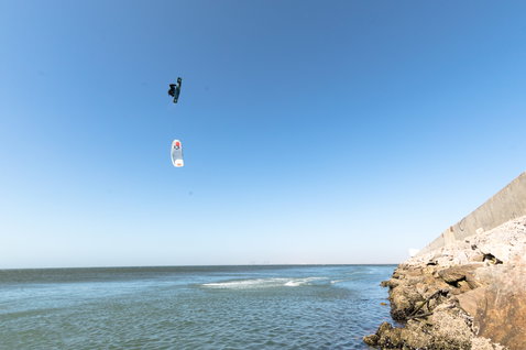 Duotone Dice LEI Kite beim Kitesurfen an der Küste mit Felswellenbrecher