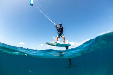 Planche de foil lors du foiling dans un océan tropical aux eaux claires et peu profondes