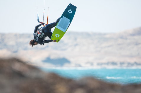 Duotone Click Bar Quad Control control bar during kitesurfing at ocean coast with arid landscape