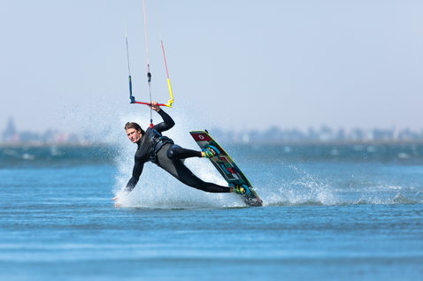 Duotone Trust Bar Quad Control Steuerbar beim Kitesurfen auf einer Flachwasser-Lagune mit Stadtsilhouette