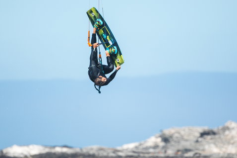 Duotone Entity Ergo 2020 kiteboard twin-tip durante el kitesurf en una costa oceánica rocosa
