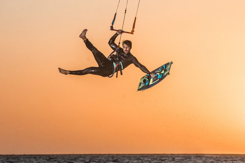 Duotone Entity Ergo 2020 kiteboard twin-tip durante el kitesurf en una playa oceánica