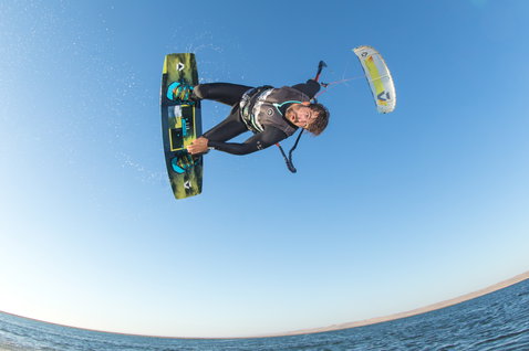 Tabla de kitesurf twin-tip Duotone Entity Ergo durante el kitesurf en la playa del océano