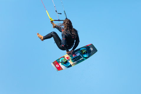 Duotone Entity Ergo twin-tip kiteboard durante el kitesurf en una toma aérea contra el cielo abierto