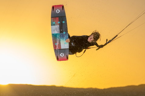 Duotone Jaime Twin-Tip Kiteboard beim Kitesurfen über der Küstenlandschaft