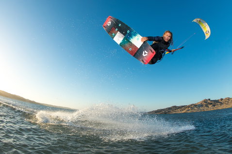 Duotone Jaime Twin-Tip Kiteboard beim Kitesurfen an der Küste mit Felsen im Hintergrund