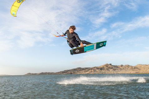 Duotone Select 2020 Kiteboard beim Kitesurfen in einer Küstenlagune mit kargen Hügeln
