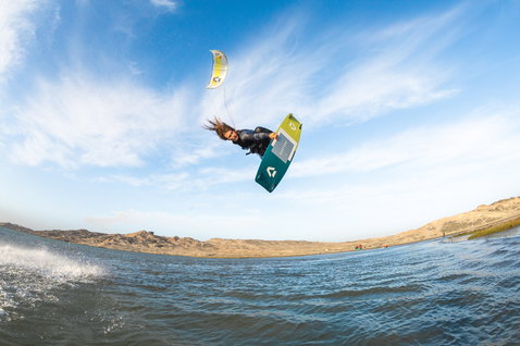 Duotone Select Textreme Twin-Tip Kiteboard beim Kitesurfen in einer Küstenlagune mit Sandhügeln