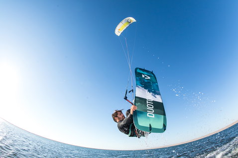 Duotone Ultraspike Textreme kiteboard twin-tip 165cm lors du kitesurf sur la plage océanique en sarcelle